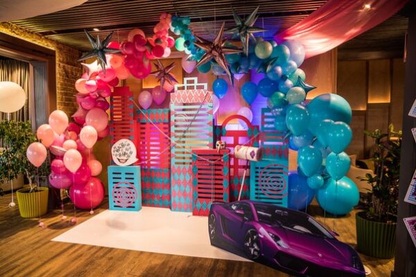 Decorative setup with colorful balloons and a toy car