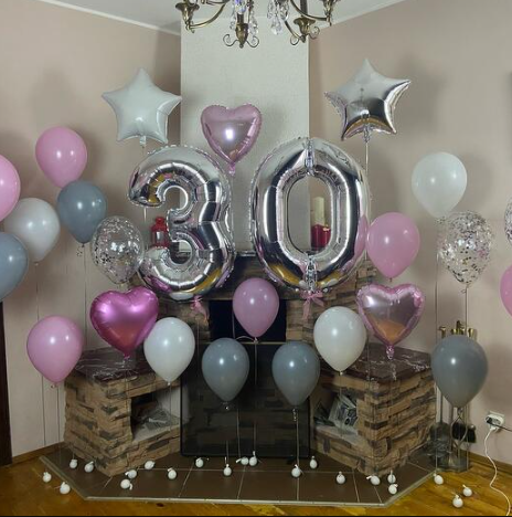 Decorative setup with silver '30' balloons and colorful balloons on seperate weights