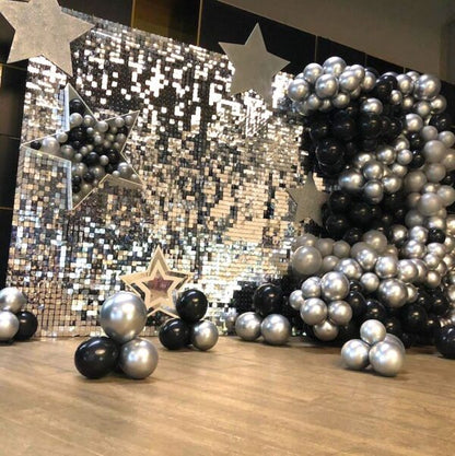 Decorative setup with chrome latex balloons and stars against a sequined backdrop