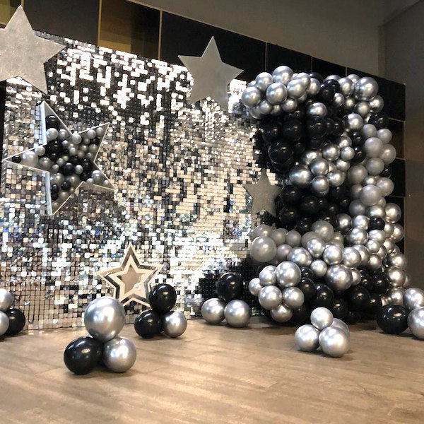 Decorative setup with chrome latex balloons and stars against a sequined backdrop