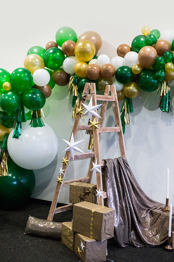 Decorative setup with balloons, a ladder, and gift boxes