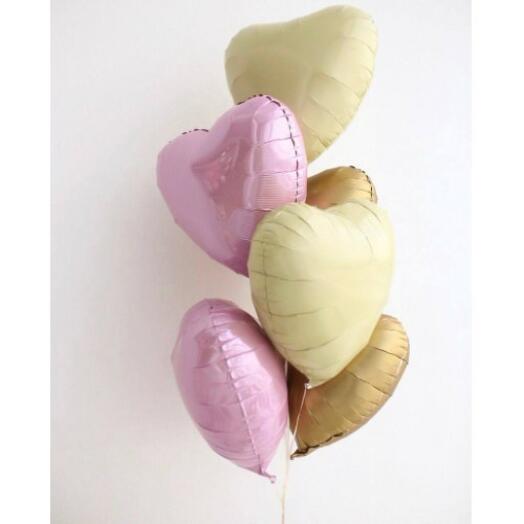 Heart-shaped balloons in pink, cream, and light brown in a bouquet