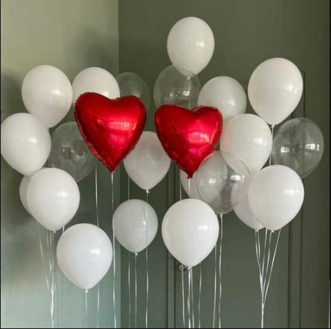 Red heart-shaped balloons among white and clear balloons 