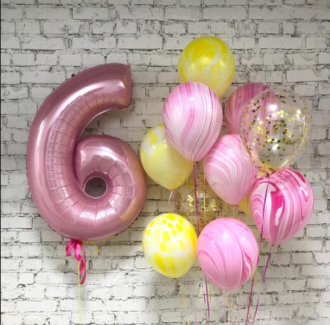 bunch of Pink, Clear and yellow balloons  with a number 6 balloon 