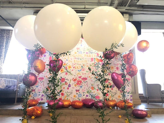 Decorative setup with latex and foil balloons and floral backdrop