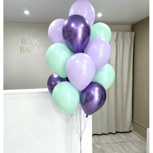 Bunch of pastel green, chrome purple, and lavender balloons in a room 
